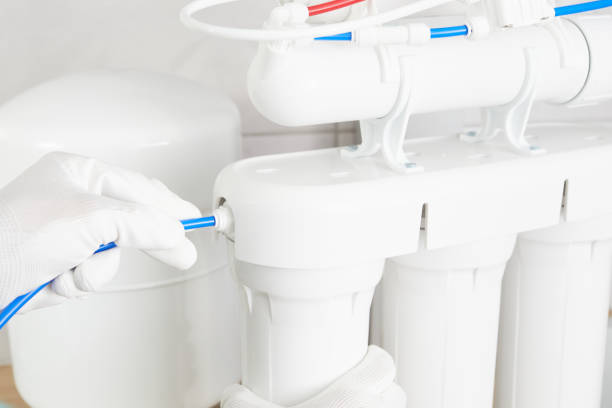 istock Installation purification osmosis system. Plumber or man hand replace water filter cartridges at home kitchen. 1284183088