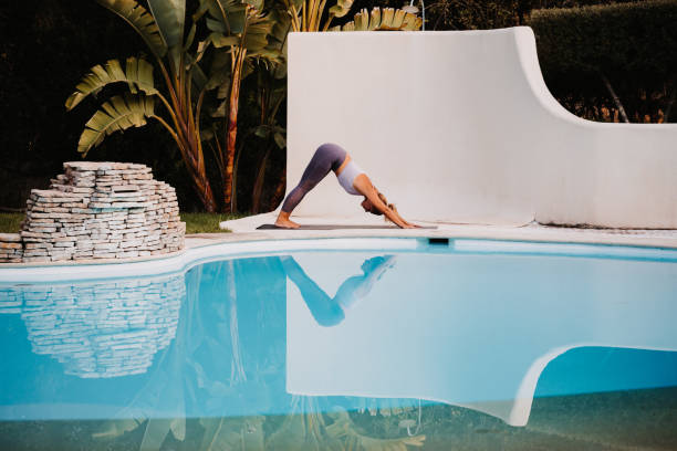 istock Young woman doing yoga at a two-colour pool 1284183728