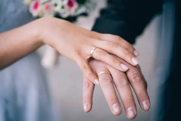 Just married - couple proudly presenting their wedding rings