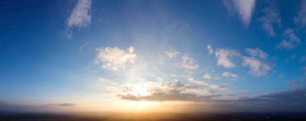 istock Blue sky and sunset, small clouds around the sun. 1284190086