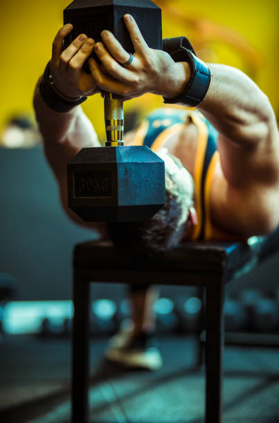 istock Strong Handsome Bodybuilder working out with dumbbell weights at the gym 1284190601