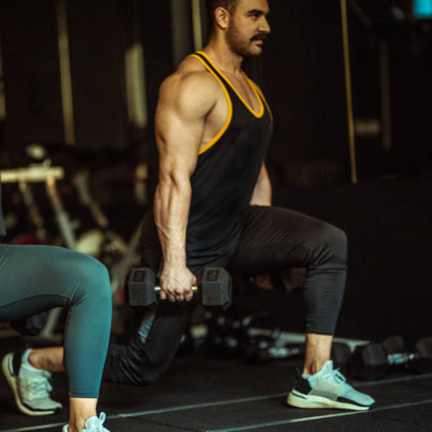 istock Strong Handsome Bodybuilder working out with dumbbell weights at the gym 1284190876