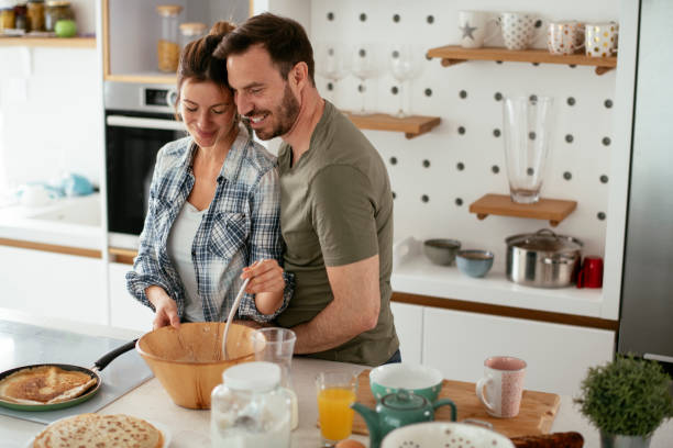 istock Husband and wife making pancakes at home 1284191739