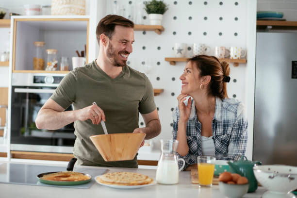 istock Husband and wife making pancakes at home 1284191754