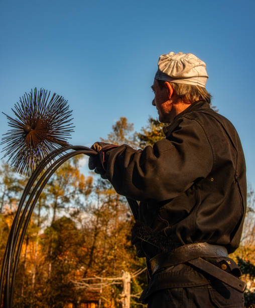 chimney sweep on roof of home at work - chimney sweeping imagens e fotografias de stock