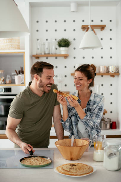 istock Husband and wife making pancakes at home 1284193452