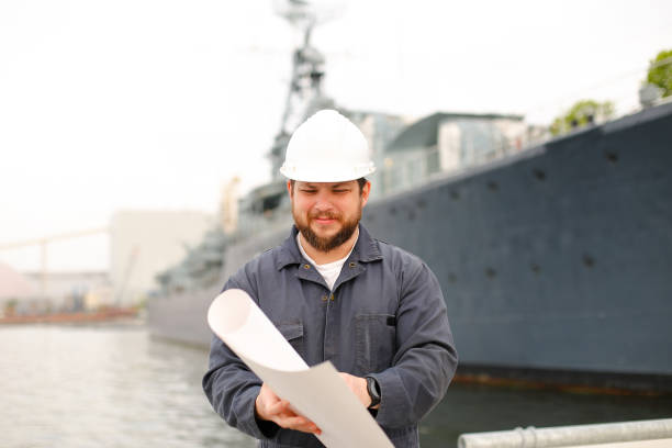 istock Maritime engineer looking at blueprints and standing near vessel 1284193535