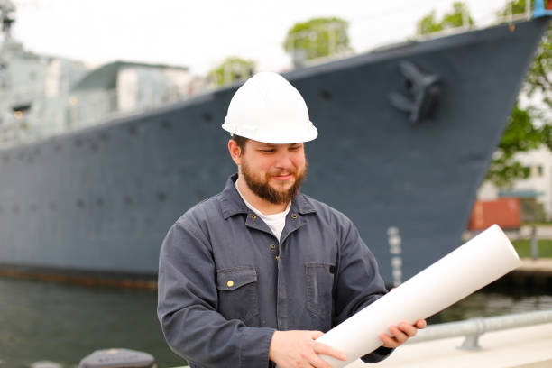 istock Marine assistant engineer looking at blueprints and standing near vessel 1284193546