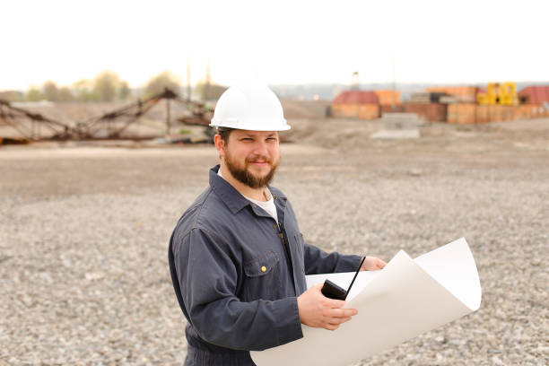 istock Caucasian foreman holding VHF walkie talkie and papers on construction site 1284193637