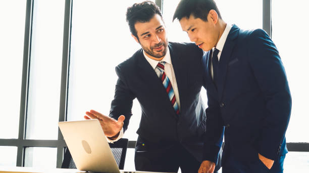 istock Two business people talk project strategy at office 1284193675