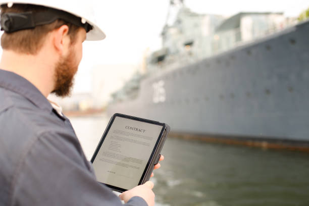 istock Captain reading contract on tablet near vessel in background 1284193752