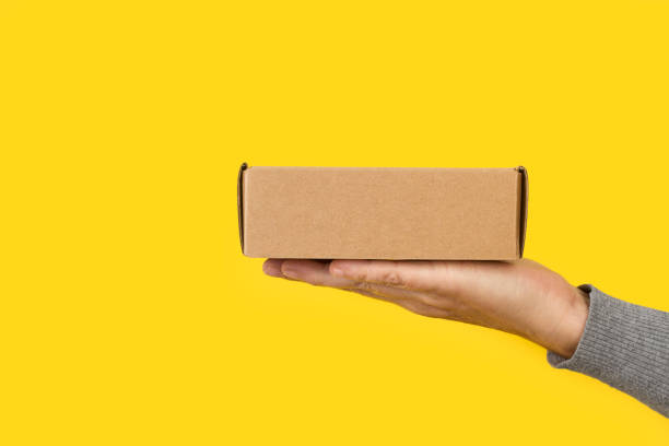 istock Woman hand holding a cardboard box 1284195058