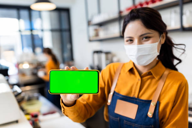 istock shopkeeper show the green screen 1284195833