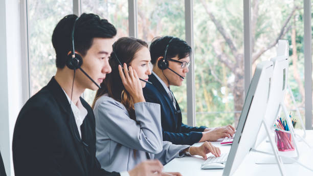 istock Business people wearing headset working in office 1284197666