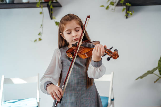 istock Little girl playing violin 1284198754
