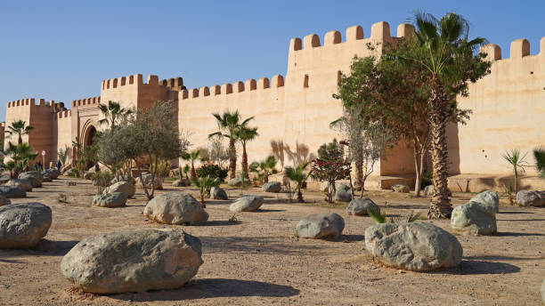istock Old Berberian town defensive wall with gate and park with palm trees 1284199529