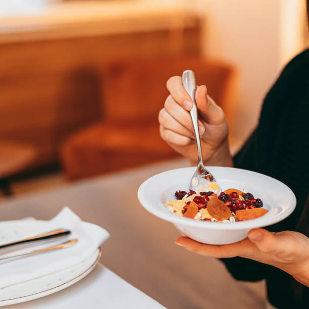 istock Young woman eating a oatmeal with berries 1284199919