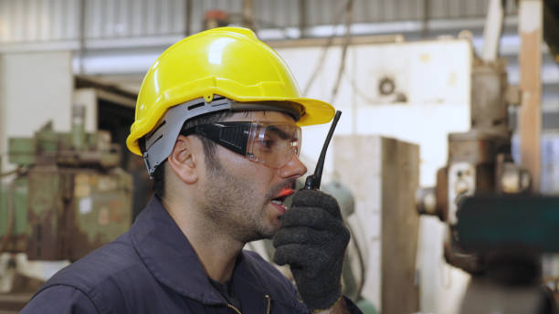 istock Factory worker talking on portable radio while inspecting machinery parts 1284200461
