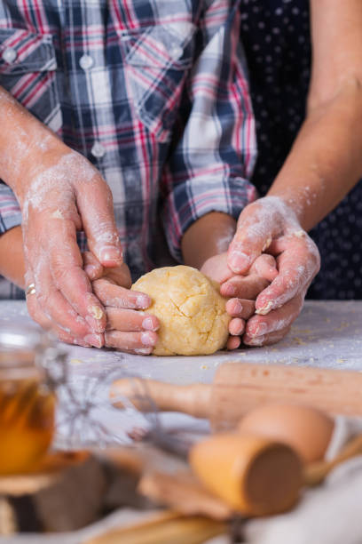 孫料理、生地をこね、台所で焼く祖母 - grandmother senior adult family domestic kitchen ストックフォトと画像