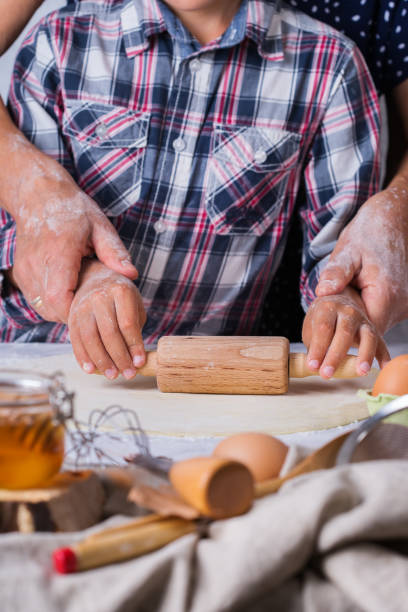 孫料理、生地をこね、台所で焼く祖母 - grandmother senior adult family domestic kitchen ストックフォトと画像