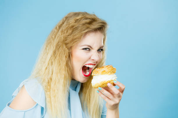 istock Funny woman holds cream puff cake 1284202498