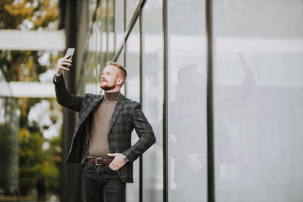 istock Fashion businessman using his smart phone and having a video call 1284203039