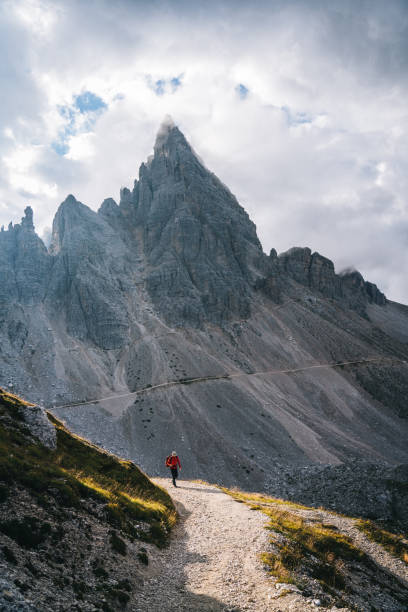 istock Male hiker traverses path on mountain ridge crest 1284203135
