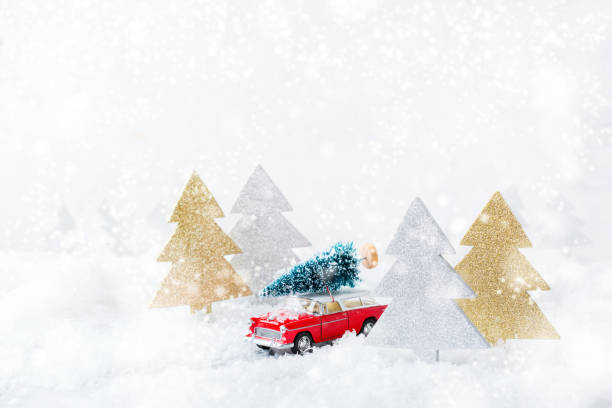 istock Toy car carrying christmas tree in a snow forest 1284203963