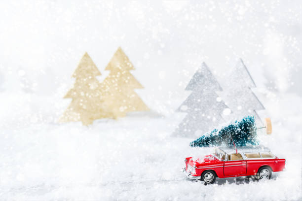 istock Toy car carrying christmas tree in a snow forest 1284203983