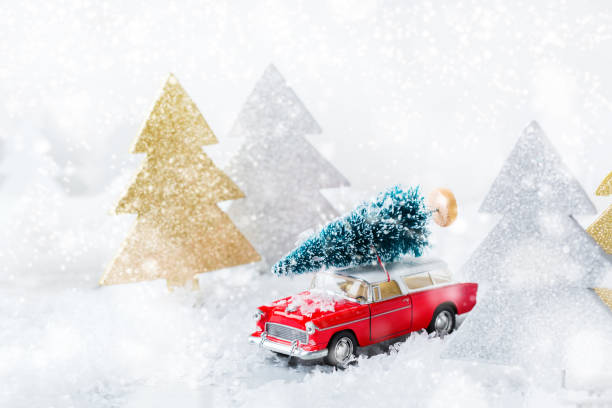 istock Toy car carrying christmas tree in a snow forest 1284203992
