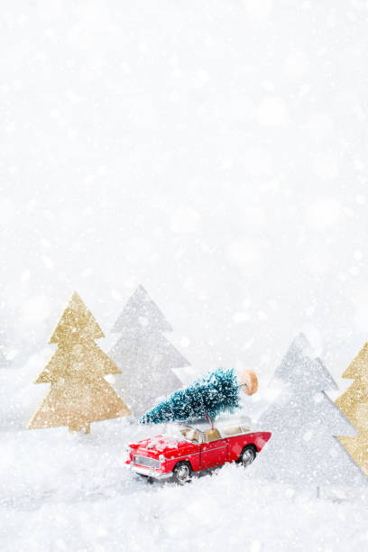 istock Toy car carrying christmas tree in a snow forest 1284203993