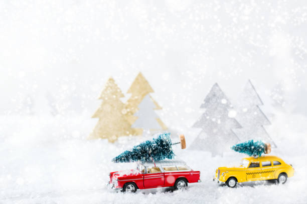 istock Toy car carrying christmas tree in a snow forest 1284204008