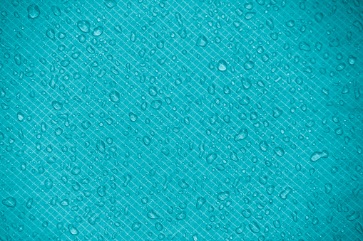 Water-repellent fabric in large raindrops. Sea blue rip-stop fabric. Tent textiles. Waterproof material.