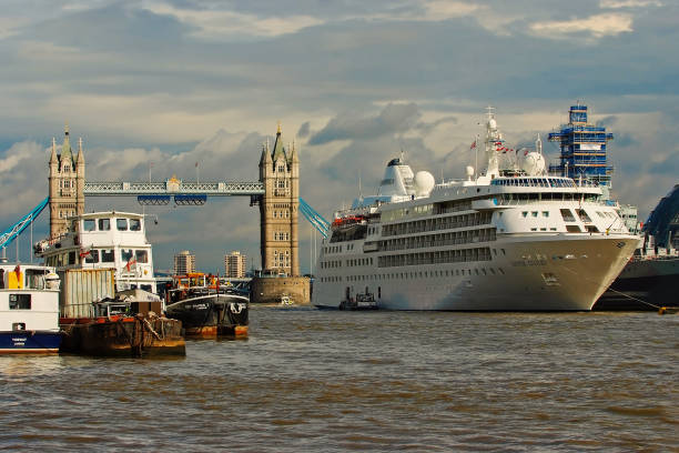 London, United Kingdom - February 25, 2010: ships on Thames river. Tower bridge on cloudy sky with nice architecture. Travelling by water. Wanderlust and adventure on summer vacation.