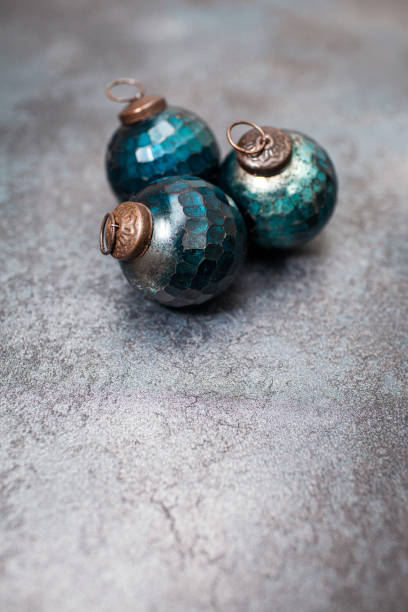 istock Retro style Christmas baubles - blue colour on a dark textured surface, with copy space 1284206488