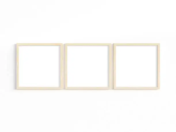 Mockup of three thin square wooden frames on a light wall. 3D illustration.