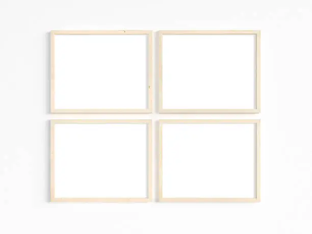 A mockup of four thin 8x10 wooden frames with landscape orientation on a light wall. Horizontal frames to display your work. 3D illustration.
