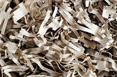 Shredded brown paper packing material close up, selective focus. Eco friendly recycled paper filling for gift boxes.