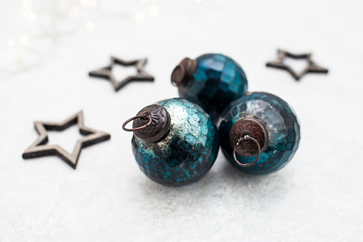 Three old-fashioned blue coloured baubles and three wooden stars with selective focus