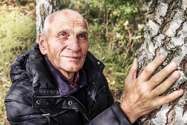 istock hand of sad senior old man on birch tree low angle shot 1284208282