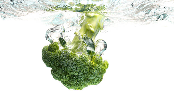 istock Green broccoli falling in water with splash on white with air bubbles 1284213019