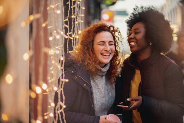 istock Two female friends outdoors during winter using smart phone 1284214255