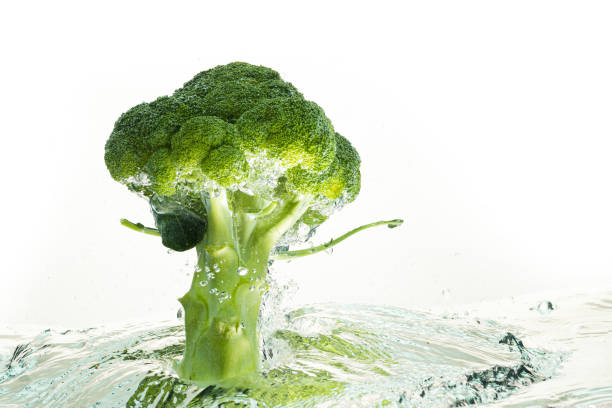 istock Green broccoli falling in water with splash on white with air bubbles 1284214593