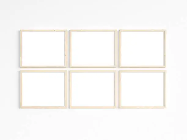 A mockup of six thin 8x10 wooden frames with landscape orientation on a light wall. Horizontal frames to display your work. 3D illustration.