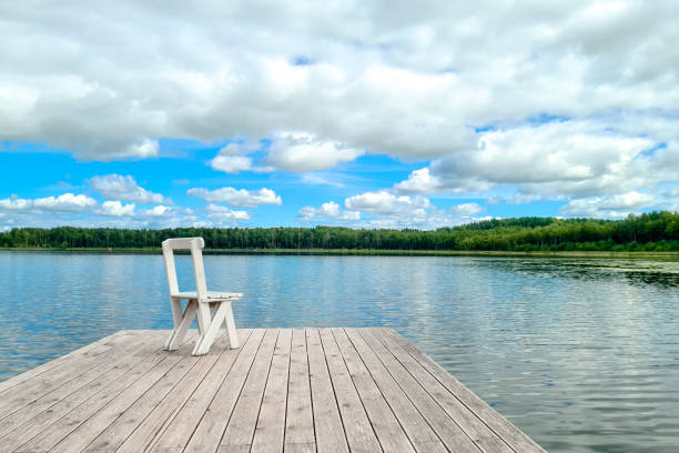 istock White empty deck chair at the lake dock. 1284214987