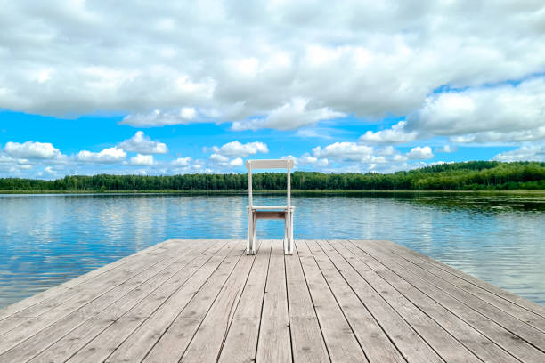 istock White empty deck chair at the lake dock. 1284214994