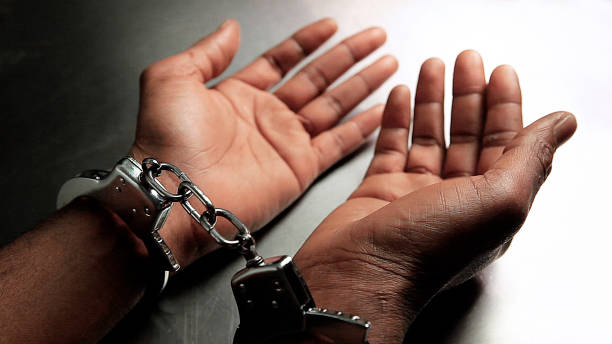 istock Handcuffed hands of an African American man 1284215552