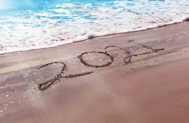 Photo of Happy New Year 2021 text on the beach
