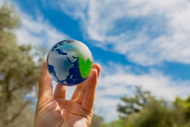 istock Hand holding a glass globe in nature 1284216023