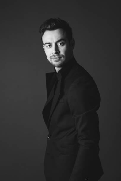 istock Studio portrait of a young man in a black blazer against plain studio background 1284218183